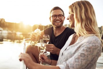 Young Couple Smiling on Boat with Wine