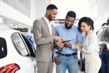 Couple buying a car with salesman