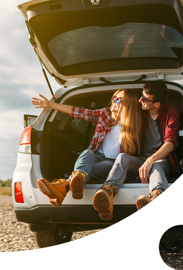A couple sitting at the back of their car