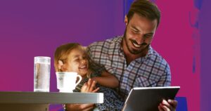 Father and Daughter at Home Laughing while dad looks at Tablet Computer