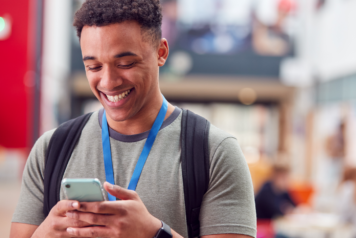 college student smiling on his phone