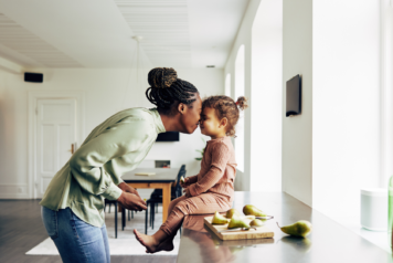 Loving Mom and Her Little Girl Having a Snack at Home