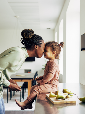 Loving Mom and Her Little Girl Having a Snack at Home